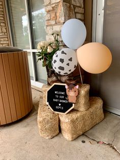 some balloons are on top of hay with a sign that says welcome to our baby showerers