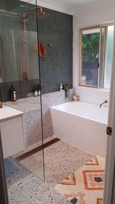 a bathroom with a bathtub, sink and shower