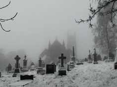 a cemetery with many headstones covered in snow