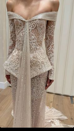 the back of a woman's wedding dress with long sleeves and an off - shoulder design