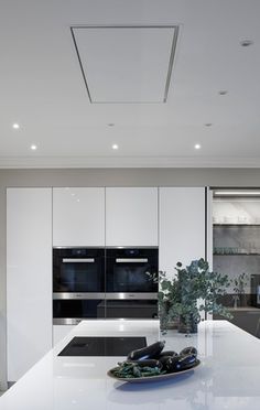 a modern kitchen with an island countertop and white cabinetry, along with stainless steel appliances