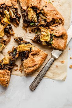 a close up of a pie on a piece of parchment paper with a slice missing