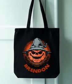 a black tote bag with an image of a pumpkin wearing a fireman's hat