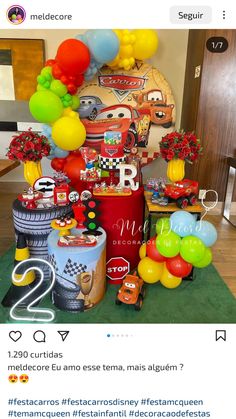 the birthday cake is decorated with cars and balloons