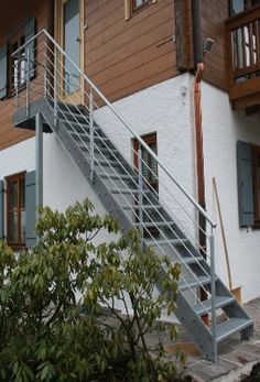 an apartment building with stairs leading up to the second floor