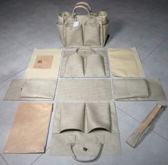 several pieces of cloth laid out on the floor, including a tote bag and other items