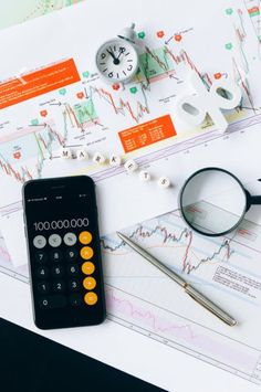 a calculator, magnifying glass and eyeglasses on top of papers