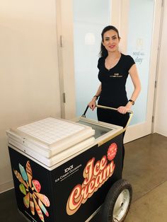 a woman standing next to an ice cream cart