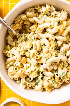 a bowl filled with macaroni and cheese on top of a yellow table cloth