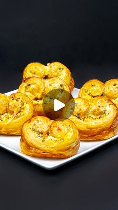 a white plate topped with mini pastries on top of a black table next to a knife