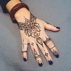 a woman's hand with henna tattoos on it