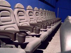 rows of seats lined up next to each other in an empty room with blue walls