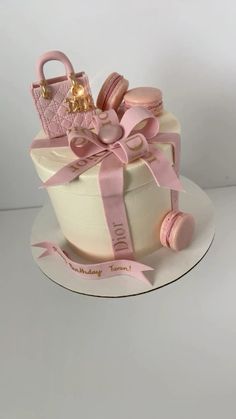 a cake that is decorated with pink and gold decorations on top of a white plate