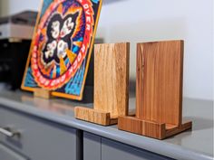 two pieces of wood sitting on top of a counter next to a clock and other items