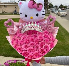 a hello kitty stuffed animal holding a bouquet of roses