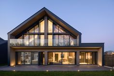 a modern house with large windows at dusk