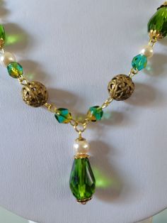 Peridot glass bead necklace. A beautifully handmade necklace with faceted glass teardrop beads as well as a mix of vintage brass filigree beads and faux pearls. This necklace is finished with a delicate chain and a push fit fastener, measuring roughly 18 inches in length. Elegant Czech Glass Necklaces With Round Beads, Elegant Czech Glass Long Necklaces, Elegant Beaded Teardrop Pendant Crystal Necklace, Handmade Drop Necklaces For Wedding, Elegant Handmade Green Chain Necklace, Beaded Czech Glass Pendant Necklace, Elegant Dangle Beaded Necklaces With Faceted Beads, Elegant Dangle Beaded Necklace With Faceted Beads, Elegant Czech Glass Drop Jewelry