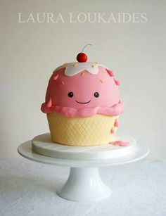 a pink cupcake with a cherry on top sitting on a white cake platter