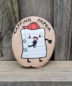 a rock with a drawing of a piece of paper on it that says, tapping paper