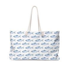 "This large beach tote bag is roomy enough to hold it all - hat, towels, sunscreen and all you need for a day at the beach.  Made from hardy poly poplin, this bag features a wide opening to easily pull things in and out, and a T-bottom so the bag sits flat when you put it down. Cotton rope handles thread through metal grommets and tied in a knot give the bag a relaxed coastal feel. The Carry All Tote features cute blue fish swimming  all over both sides of the bag. The bag fabric is white with a White Beach Bag For Vacation, Large Capacity Cotton Bag For Vacation, Summer Large Capacity Cotton Beach Bag, Large Capacity Cotton Beach Bag For Summer, Large Blue Beach Bag For Travel, Summer Beach Bag Made Of Canvas, Canvas Bucket Beach Bag For Vacation, Coastal Beach Bag For Vacation, Coastal Style Beach Bag For Vacation Travel