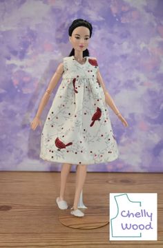 a doll wearing a white dress with red birds on it's chest and legs