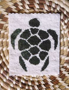 a close up of a woven object with a sea turtle on it's back