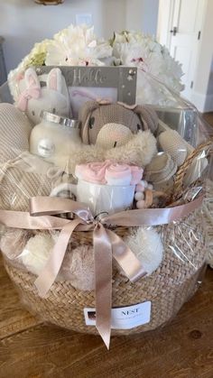 a basket filled with lots of baby items on top of a wooden floor next to a wall