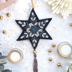 an ornament hanging on a table next to candles and other holiday decor items