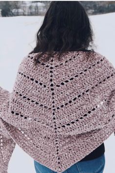 a woman wearing a pink crocheted shawl in the snow