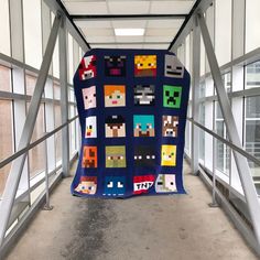 a quilt made to look like video game characters is hanging on the side of a building