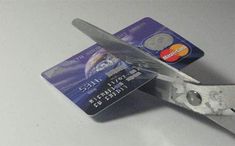 a pair of scissors cutting through a credit card