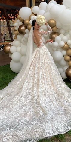 a woman in a wedding dress standing next to balloons