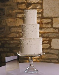 a three tiered cake with white frosting on a table