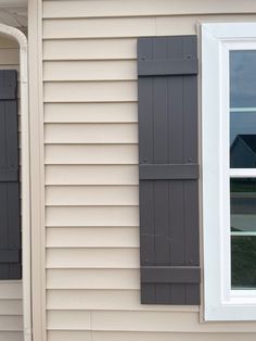 two gray shutters on the side of a house