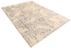 a beige and blue area rug with an intricate design on the bottom, in front of a white background