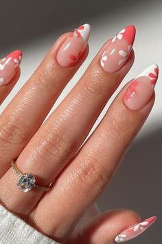 a woman's hand with pink and white nail polish