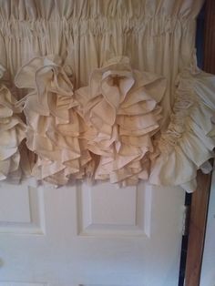 a close up of a curtain with ruffles hanging on the side of a door