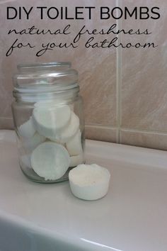 a jar filled with white marshmallows sitting on top of a bathroom counter