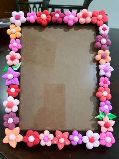 a frame made out of plastic flowers on top of a table