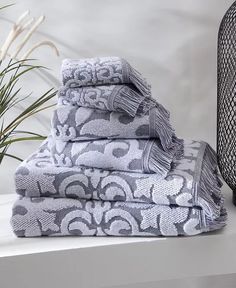 towels stacked on top of each other next to a vase