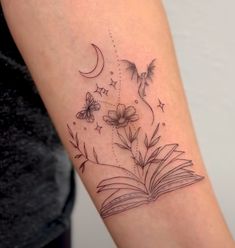 a woman's arm with a book and flowers on it