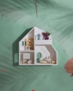 a doll house with furniture and accessories in the shape of a house on a green background