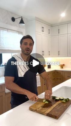 a man cutting cucumbers on top of a wooden cutting board in a kitchen