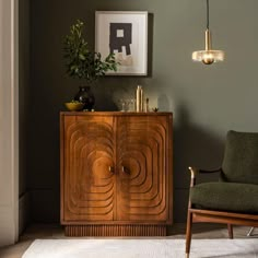 a living room with a chair, sideboard and pictures on the wall above it