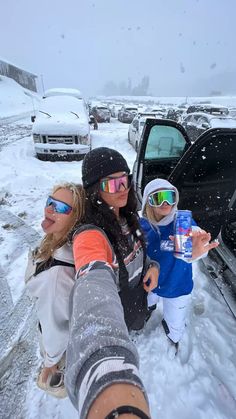 two women and a child standing in front of a car with snow on the ground