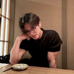 a man sitting at a table in front of a plate with chopsticks on it