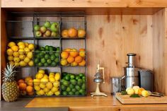 there are many fruits on the shelves in this kitchen, including pineapples and oranges