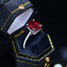 an engagement ring with a red stone in it