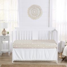 a white crib with a beige blanket on it