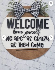 a welcome sign hanging on the side of a brick wall that says, welcome home yourself we are as crazy as they come